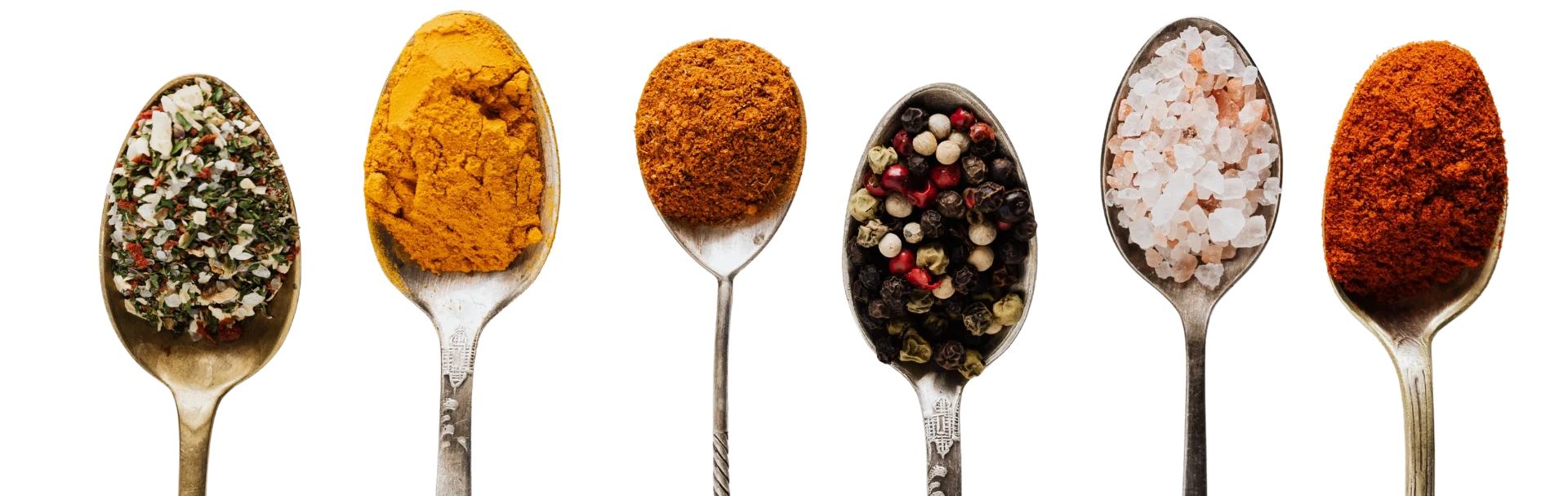 Cucharas con especias: hierbas aromáticas, cúrcuma, pimentón, pimienta de colores, sal rosa y paprika